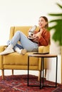 Microphone, smile and woman hosting a podcast on a chair by a wall in her modern home. Radio, broadcast and happy young