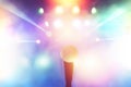 Microphone on stage in concert hall with colorful light blurred