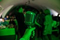 Microphone is on stage in a nightclub. Singer holds and sings into the microphone. Bright light of the club Shine on the MIC. Royalty Free Stock Photo