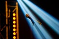 A microphone on a stand of a classic look in the light of the spotlights shot on a dark background