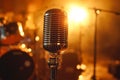 A microphone on a stand in front of a stage with a drum set Royalty Free Stock Photo