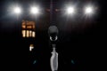 Microphone on the stand with hand nozzle in the center tage with beautiful bokeh spotlights in the background