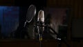 Microphone on a stand located in a music studio recording booth under low key light Royalty Free Stock Photo