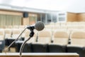 Microphone stand on podium with abstract blur photo of conference hall or seminar room in background. Business seminar concept.