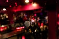 Microphone on a stand up comedy stage with colorful bokeh , high contrast image Royalty Free Stock Photo