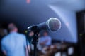 Microphone stands on stage in a nightclub. Bright club light shines on MIC. Performances in the night club Royalty Free Stock Photo