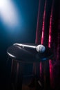 Microphone on a wooden stool on a stand up comedy stage with reflectors ray, high contrast image Royalty Free Stock Photo