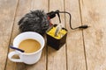 The microphone is used to connect to a DSLR camera and mobile phone with a coffee in a white mug, and a cactus in a pot on a