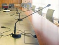 Microphone on a wooden table and empty chairs in a boardroom Royalty Free Stock Photo