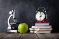 Microscope, alarm clock, books and apple Royalty Free Stock Photo