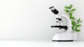 Microscope on a desk with plant white isolated background Royalty Free Stock Photo