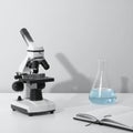 Microscope and Erlenmeyer Flask on White Desk Royalty Free Stock Photo