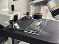 Microscope examining a specimen on a glass slide with detailed focus on the sample concept Royalty Free Stock Photo