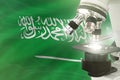 Saudi Arabia science development concept - microscope on flag background. Research in medicine or physics 3D illustration of