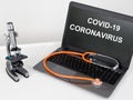 Microscope and stethoscope on black keyboard laptop coronavirus in screen  in a medical office Royalty Free Stock Photo