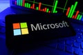 Microsoft Company Logo On Mobile Display with Stock Financial Performance Graph Chart Background Royalty Free Stock Photo