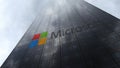 Microsoft logo on a skyscraper facade reflecting clouds. Editorial 3D rendering