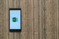 Microsoft office excel logo on smartphone screen on wooden background. Royalty Free Stock Photo