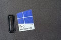 Microsoft Windows 8 Pro sticker closeup on old laptop casing, Win8 operating system logo badge on black textured computer cover, Royalty Free Stock Photo