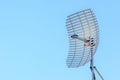 Microwave antenna dish on blue sky background.