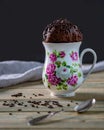 Microwave brownie chocolate mug cake ready to eat, on a wooden table and black background. Front view, copy space Royalty Free Stock Photo