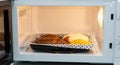 Microwaved dinner: meat patties, mashed potatoes, and corn on a tray in a kitchen setting Royalty Free Stock Photo