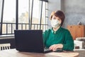 Mid adult business woman in face mask working laptop computer indoors Royalty Free Stock Photo