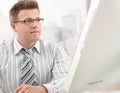Mid-adult businessman looking at computer screen Royalty Free Stock Photo