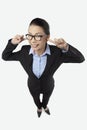 Mid adult businesswoman being cheeky by covering her ears. Conceptual image