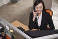 Mid adult businesswoman smiling and listening on the phone in the office Royalty Free Stock Photo