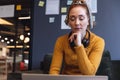 Mid adult caucasian businesswoman with hand on chin working on laptop in office Royalty Free Stock Photo