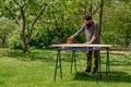 Mid adult caucasian man in the garden sanding wooden planks. DIY home improvement, restoration, carpentry concept. Royalty Free Stock Photo