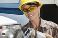 Mid adult female industrial worker buffing a truck engine cylinder