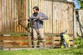 Mid adult man cleaning a wooden gate with a power washer. High water pressure cleaner used to DIY repair garden gate. Royalty Free Stock Photo