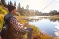 Mid-adult man fishing by lakeside, Big Bear, California, USA Royalty Free Stock Photo