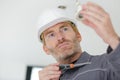 mid-adult man fixing light bulb wiring in new house Royalty Free Stock Photo