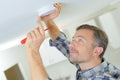 mid-adult man fixing light bulb wiring in new house Royalty Free Stock Photo