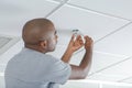 mid-adult man fixing light bulb wiring in new house Royalty Free Stock Photo