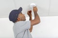 Mid-adult man fixing light bulb wiring in new house Royalty Free Stock Photo