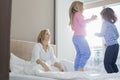 Mid adult parents looking at playful children in bedroom Royalty Free Stock Photo