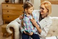 Mid-adult pediatrician examining a sick brown-haired girl using a stethoscope