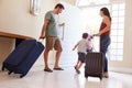 Mid adult white couple and kids leaving their home with luggage to go on vacation, full length Royalty Free Stock Photo