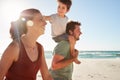 Mid adult white couple walking on a beach, dad carrying son on his shoulders, close up, lens flare Royalty Free Stock Photo