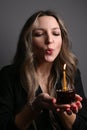 Mid adult woman blowing birthday candle. Close up portrait of dreamy, happy birthday woman. Vertical view Royalty Free Stock Photo