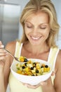 Mid Adult Woman Eating A Bowl Of Fresh Fruit Royalty Free Stock Photo