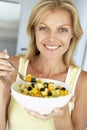 Mid Adult Woman Eating A Bowl Of Fresh Fruit Royalty Free Stock Photo