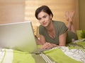 Mid-adult woman looking at computer in bed Royalty Free Stock Photo