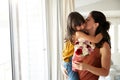 Mid adult woman holding her daughter, whoÃ¯Â¿Â½s given her a bunch of flowers on her birthday, waist up