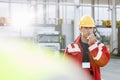 Mid adult worker using walkie-talkie in shipping yard