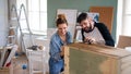 Mid adults couple painting furniture indoors at home, relocation and diy concept. Royalty Free Stock Photo